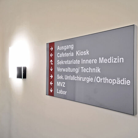 Innenwerbung – Leitsysteme: Wandschild mit Wegweisern. Produziert von Beschriftung - Siebdruck Mühle e. K., Bad Kissingen.